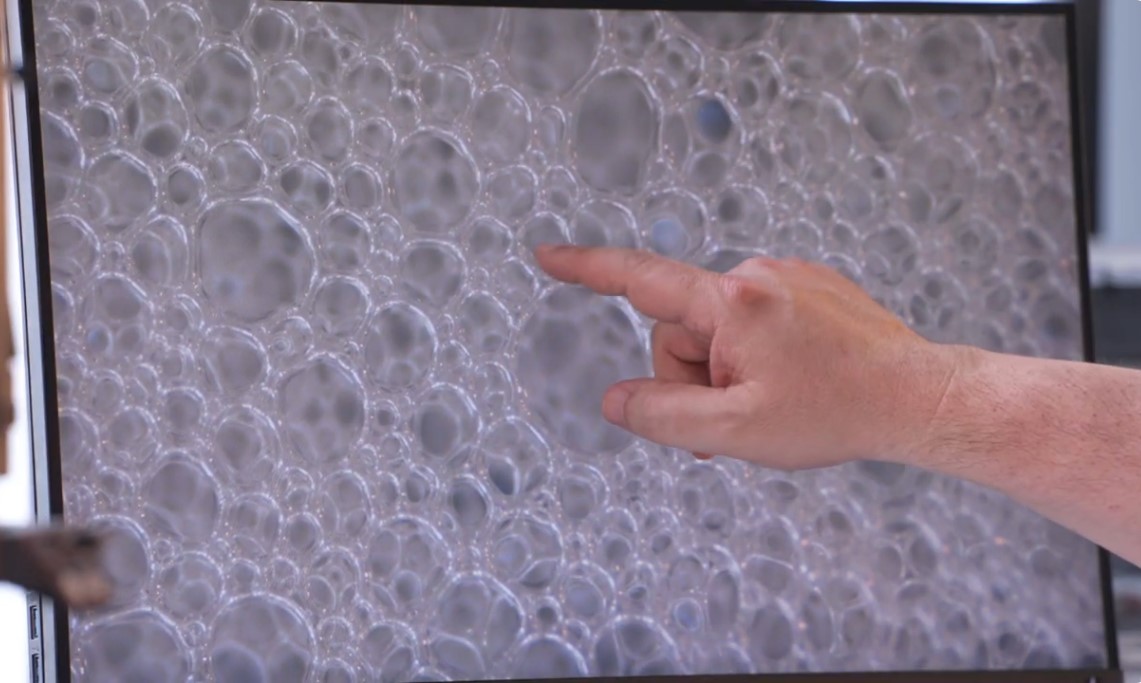 Olivier Pitois pointing at the bubbles of his foam